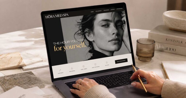 Medical spa web designer reviewing website on laptop